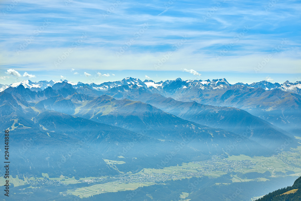 Mountain landscape in Austria, cloudy, forests, rocks, city in the mountains, summer