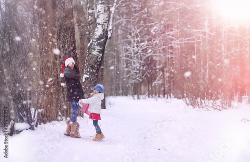 A winter fairy tale,in the forest. A girl on a sled with gifts on the eve of the new year in the park. Two sisters walk in a New Year's park and ride a sled with gifts.