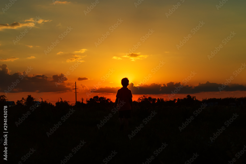Silhouette of a boy against the backdrop of the dawn sun Silhouette of a boy against the backdrop of the dawn sun