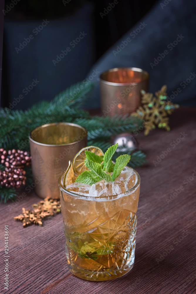 Christmas cockatail with ice and mint on wood table over pine branch Christmas cockatail with ice and mint on wood table over pine branch