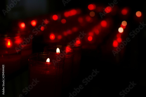 Red candles burning in a row. Church of the Divine Salvador (Capilla de la Pasión), Seville, Andalusia, Spain. Selective focus