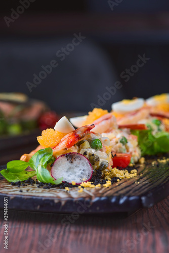 Salad of shrimp, green peas, tomatoes and radish on a white plate, food styling