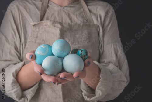 Easter eggs painted in blue natural color in hands woman in abon photo