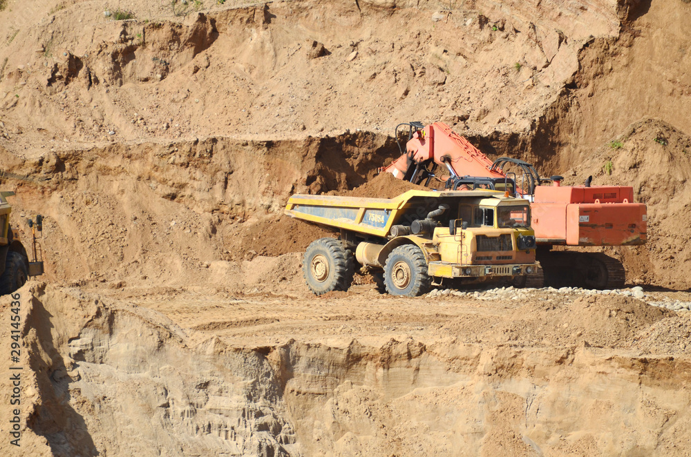 Excavator developing the sand on the opencast and loading it to the heavy dump truck. Processing of loose material in mining quarry. Drill, breaking, processing plant, crushing and screening - Image Excavator developing the sand on the opencast and loading it to the heavy dump truck. Processing of loose material in mining quarry. Drill, breaking, processing plant, crushing and screening - Image