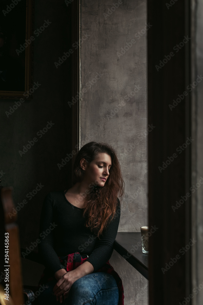 Attractive brunette in a cafe drinking coffee Attractive brunette in a cafe drinking coffee