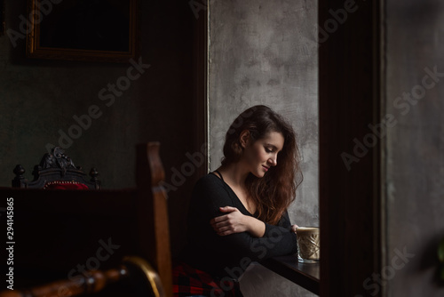 Beautiful woman with lohg brunette hair in a cafe  © iwavephoto