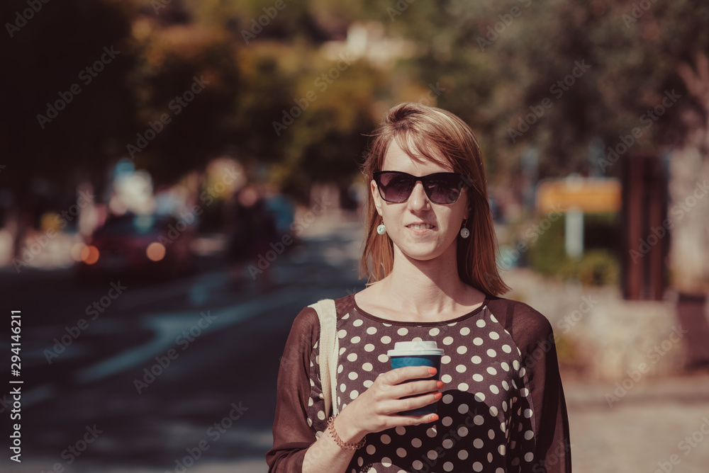 Pretty girl in sunglasses and elegant dress walking in city center, she drinking cappuccino and enjoying it. Pretty girl in sunglasses and elegant dress walking in city center, she drinking cappuccino and enjoying it.