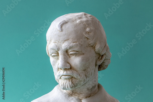 Sculpture d'un visage d'homme sur fond bleu turquoise