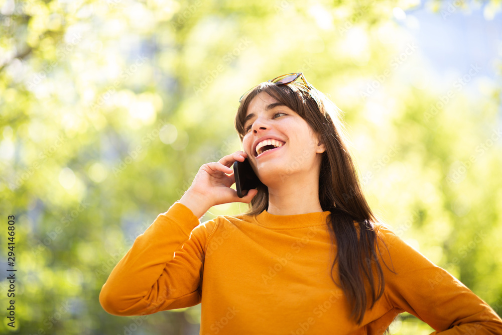 happy young woman talking with cellphone in park happy young woman talking with cellphone in park