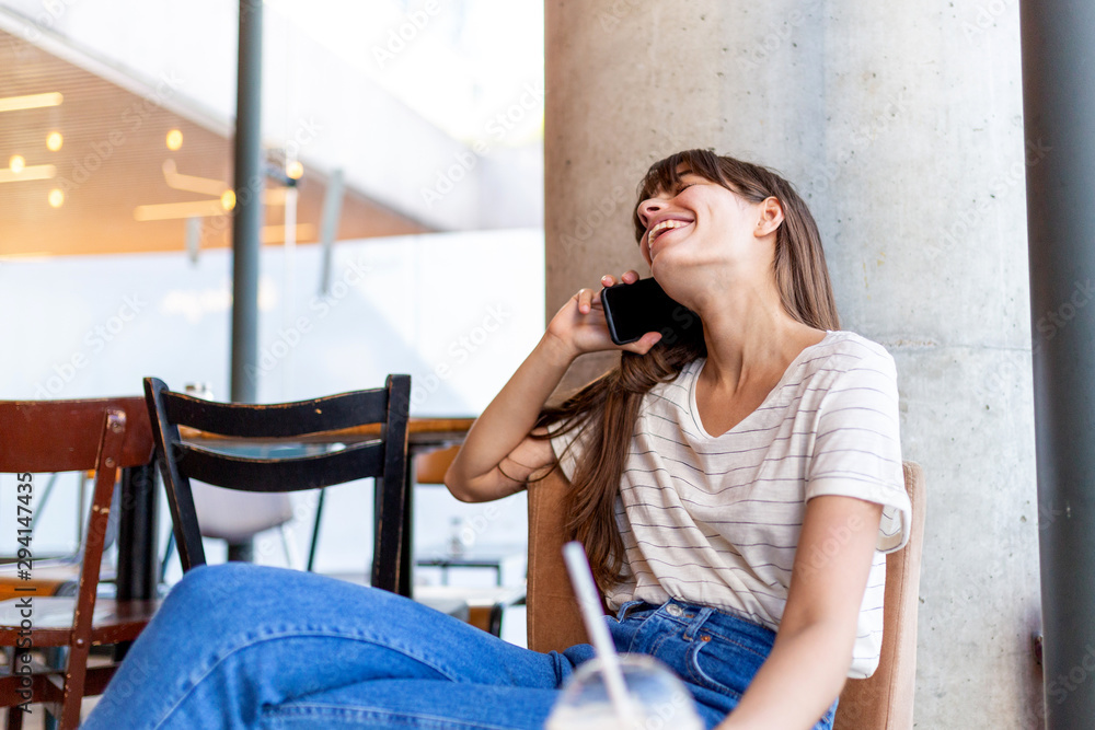 happy young woman sitting at cafe and talking with mobile phone happy young woman sitting at cafe and talking with mobile phone
