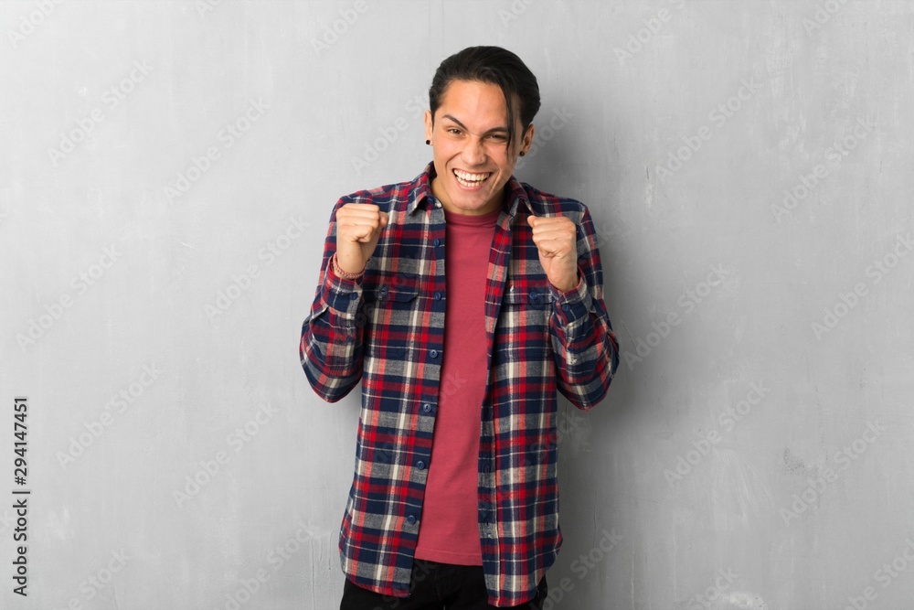 Man over grunge wall celebrating a victory in winner position Man over grunge wall celebrating a victory in winner position