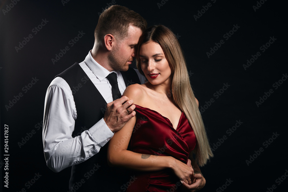beautiful blonde woman undressed by her boyfriend, close up portrait, isolated black background, studio shot