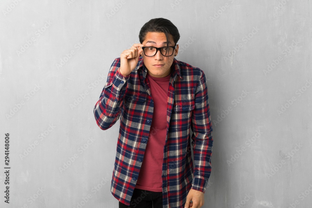Man over grunge wall with glasses and surprised Man over grunge wall with glasses and surprised