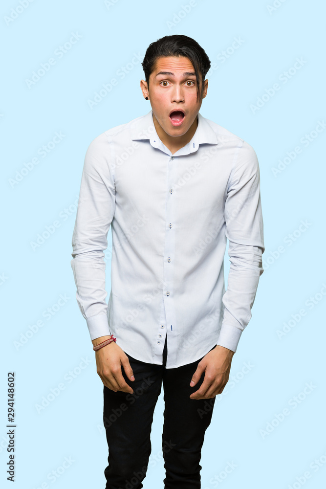 Handsome man with surprise and shocked facial expression over isolated blue background Handsome man with surprise and shocked facial expression over isolated blue background