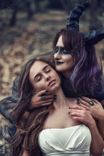 Demoness going to sacrifice the bride in magic autumn forest. Ritual with virgin. Dracula`s bride photo