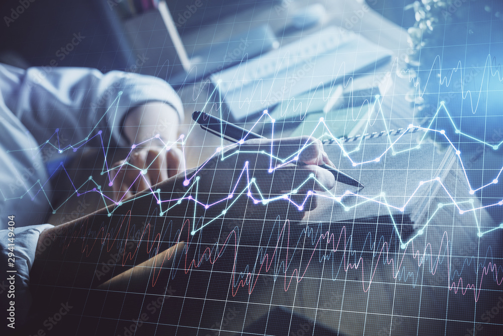 Financial forex charts displayed on woman's hand taking notes background. Concept of research. Double exposure Financial forex charts displayed on woman's hand taking notes background. Concept of research. Double exposure