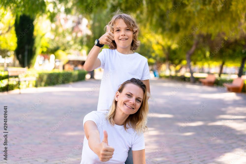 Happy mother and son in a park with thumb up Happy mother and son in a park with thumb up