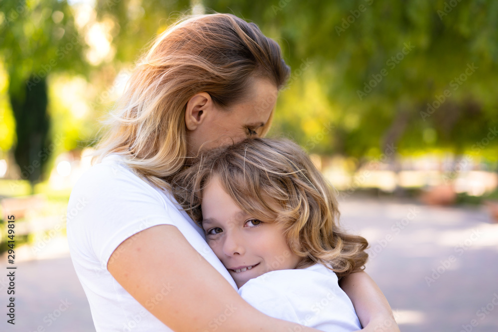 Happy mother and son in a park hugging and hugging Happy mother and son in a park hugging and hugging