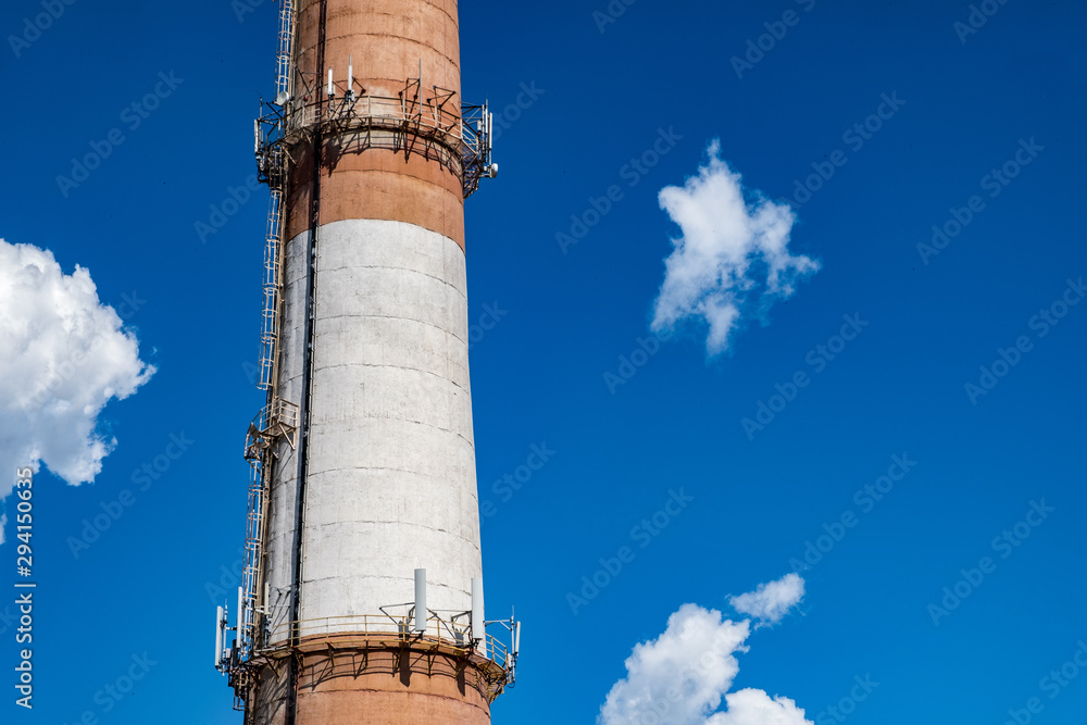 Brick chimney of a factory boiler room. Brick chimney with red and white stripes Brick chimney of a factory boiler room. Brick chimney with red and white stripes