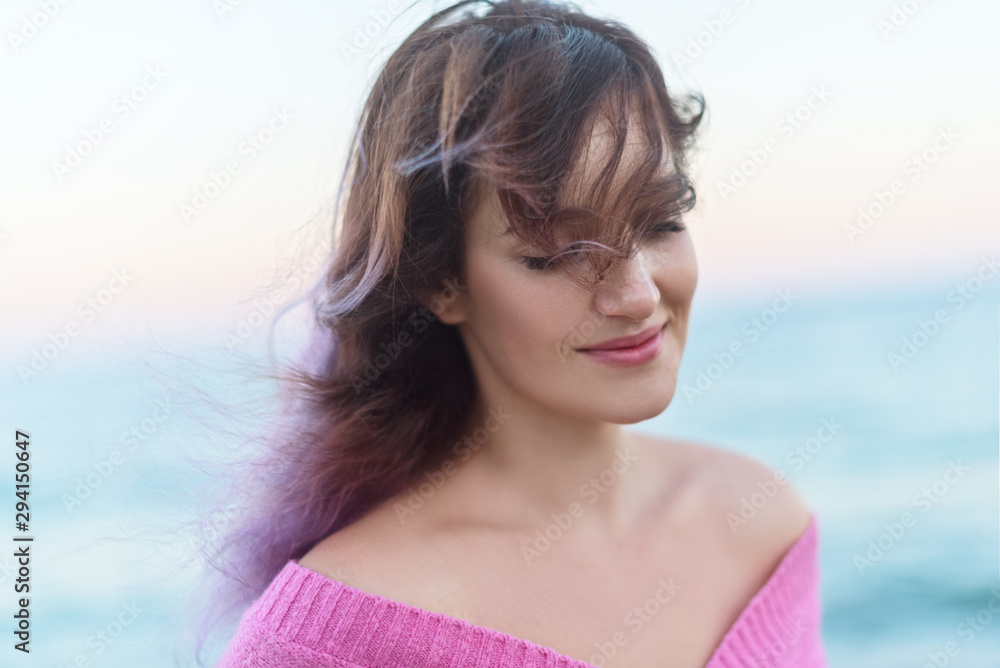 Portrait of a beautiful woman with purple long hair over the sea, the concept of female emotions Portrait of a beautiful woman with purple long hair over the sea, the concept of female emotions