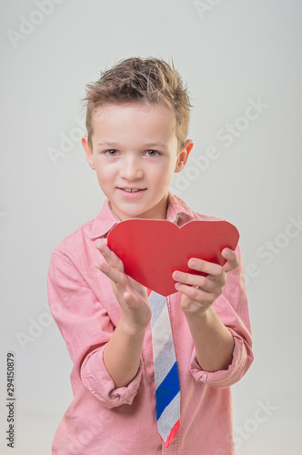 Handsome boy holding red heart. Gift for girlfriend in Valentine's day
