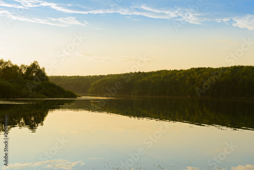 Summer evening landscape with a lake and forest on the shore
