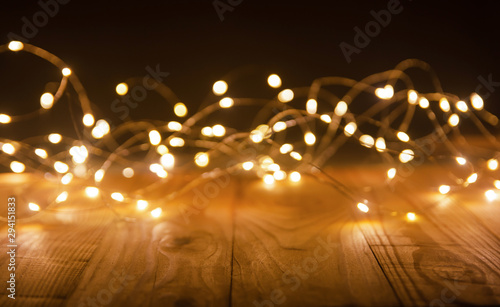 Defocus christmas lights on wooden background. selective focus on wood planks