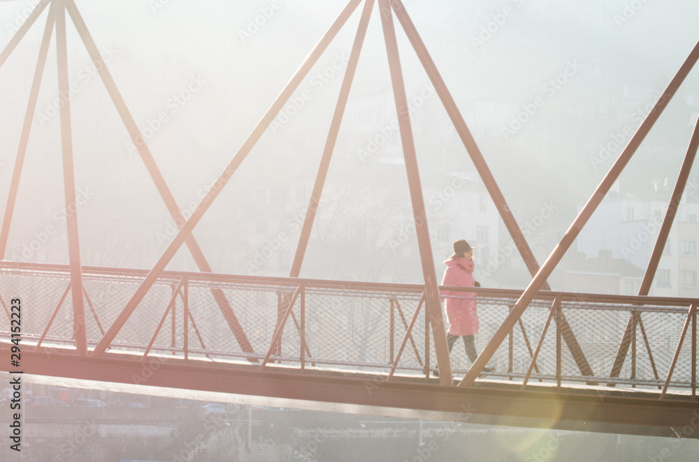 une femme passe sur un pont suspendu