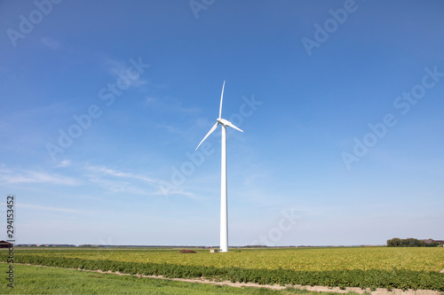 One wind turbine in a field in Almere, Netherlands, using wind to make electricity.
