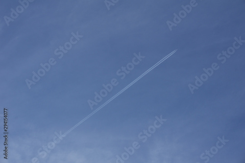 Vapour trail across clear blue sky