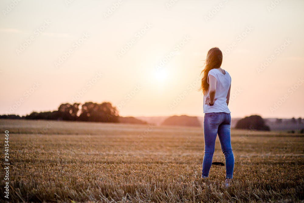 Frau auf dem Feld im Sonnenuntergang