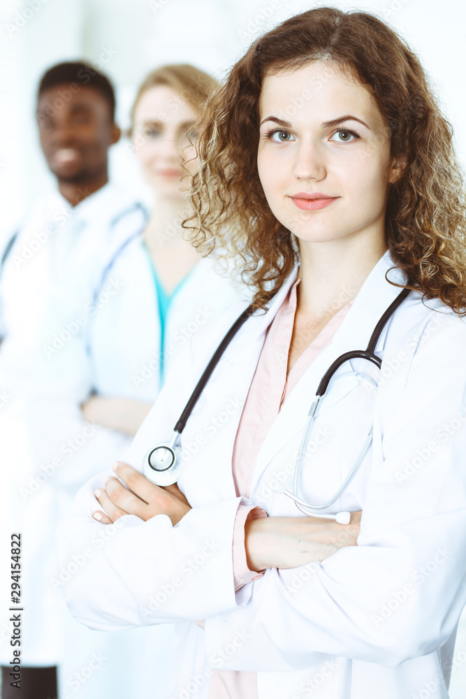 Happy doctor woman with medical staff at the hospital. Multi ethnic people group Happy doctor woman with medical staff at the hospital. Multi ethnic people group