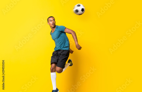Afro futbolu amerykańskiego gracza mężczyzna nad odosobnionym żółtym tłem