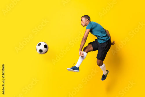 Afro futbolu amerykańskiego gracza mężczyzna nad odosobnionym żółtym tłem