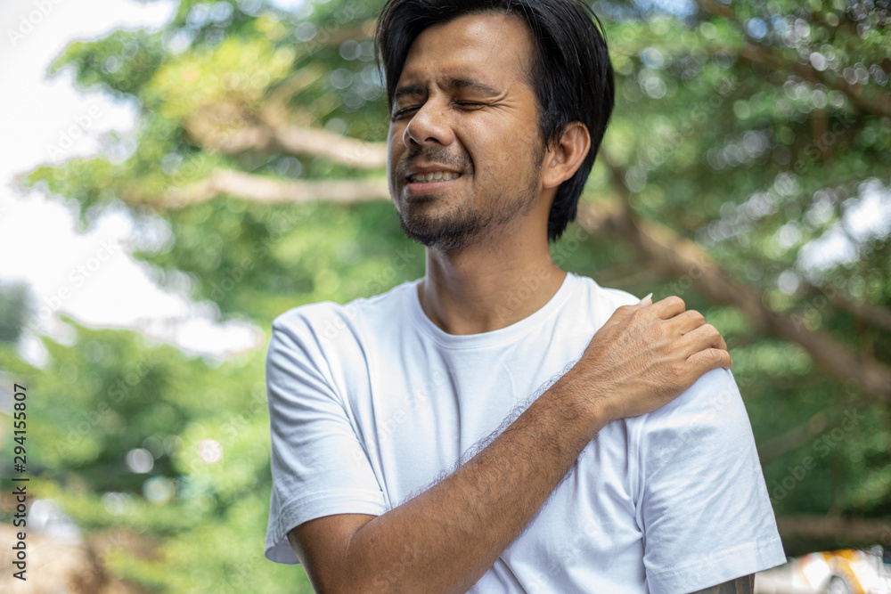 young asian man with pain in shoulder , health care concept young asian man with pain in shoulder , health care concept