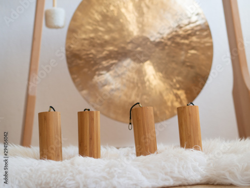 Konstfotografi Koshi chimes sound healing instruments standing in front of a big golden Gong