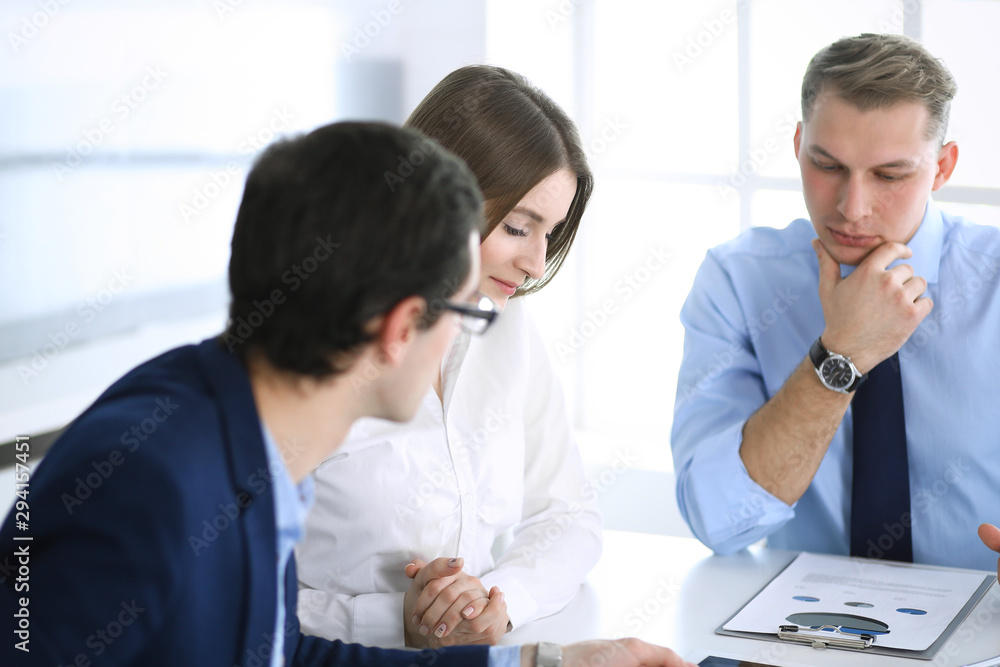 Obraz premium Group of business people discussing questions at meeting in modern office. Managers at negotiation or brainstorm. Teamwork, partnership and business concept
