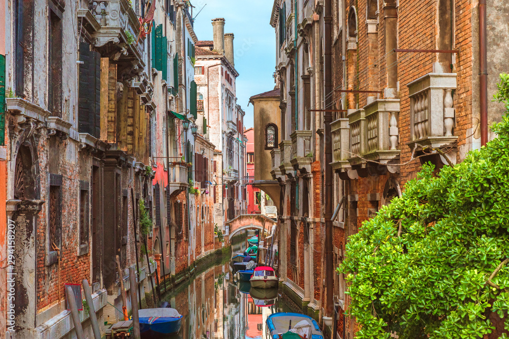 Beautiful view of Venice canal with traditional boats and colorful buildings in Venice, Italy
