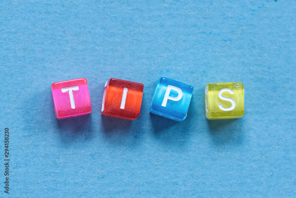 Tips inscription made of colorful small cubes on blue background. Tips inscription made of colorful small cubes on blue background.