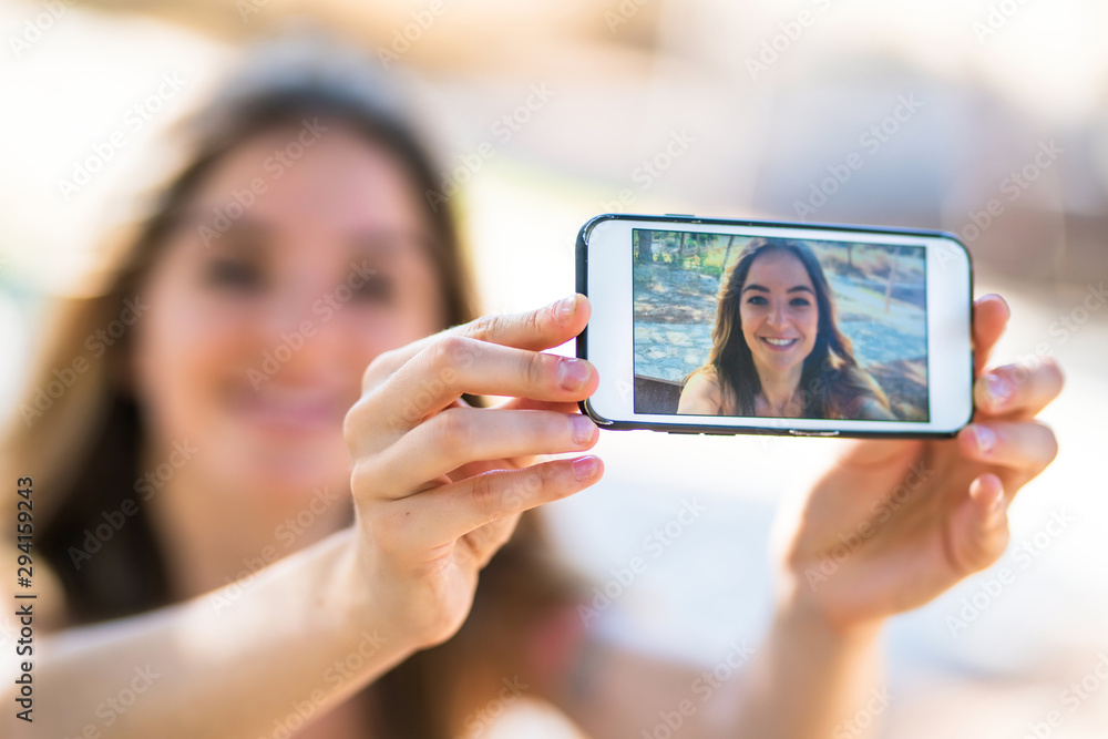 Young girl at outdoors taking a selfie with the mobile