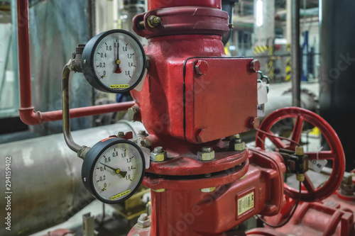 Gauge closeup, pressure measurement . Pipes and valves in the industrial enterprise.