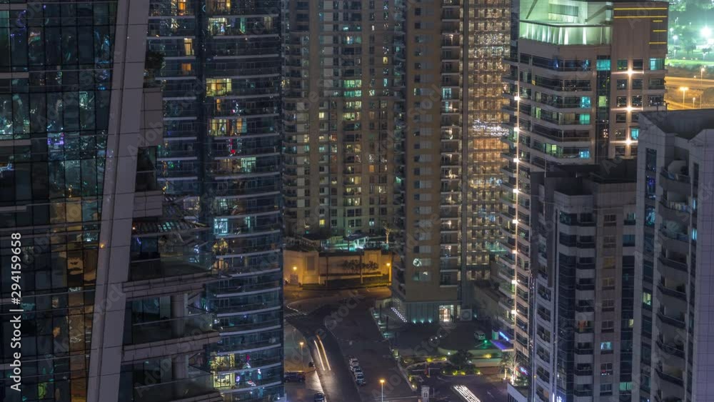 View of various skyscrapers and towers in Dubai Marina from above aerial night timelapse. Illuminated modern buildings in urban skyline with traffic on streets View of various skyscrapers and towers in Dubai Marina from above aerial night timelapse. Illuminated modern buildings in urban skyline with traffic on streets