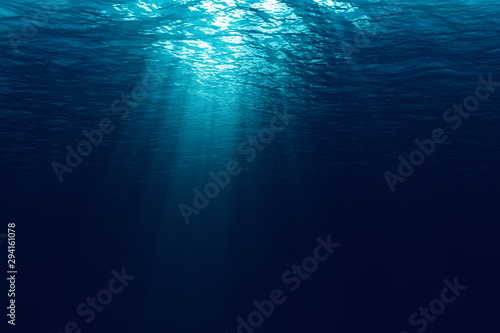perfectly seamless of deep blue ocean waves from underwater background with micro particles flowing, light rays shining through