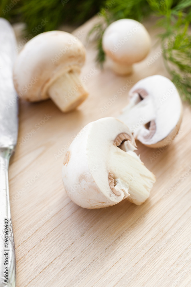 Sliced champignon mushrooms on wooden board Sliced champignon mushrooms on wooden board