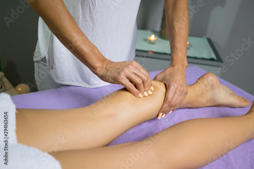 Female relaxing leg massage with hands. Beauty body skin care treatment concept.