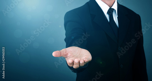 Bild auf Leinwand Asian Man standing and shows outstretched hand with open palm on Light of Len flare and Boke blue background