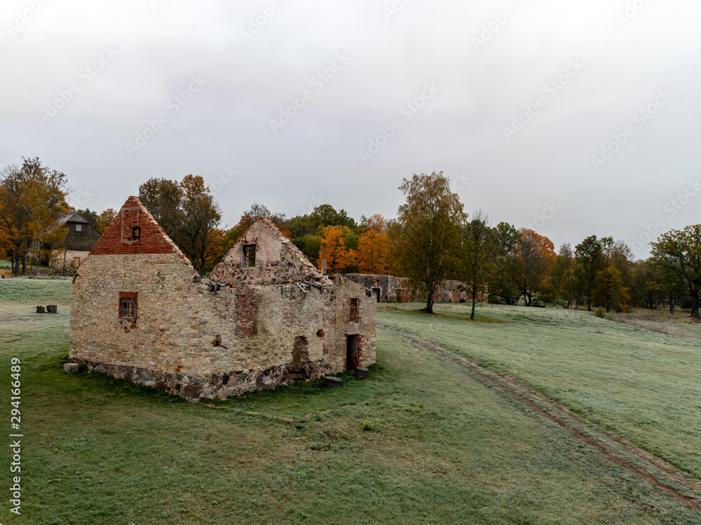 old stone building with round arched windows, autumn