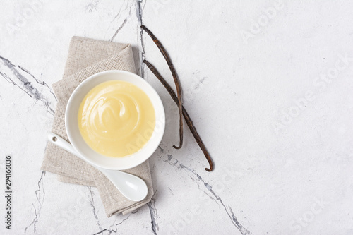 Canvas Print Bowl of vanilla sauce with spoon