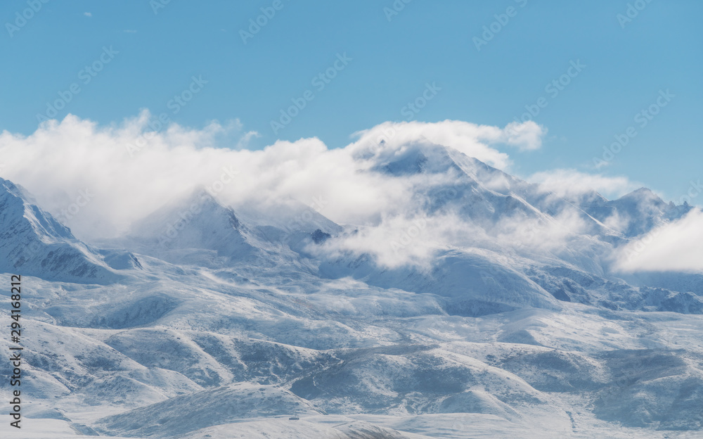 Panoramic snow mountains with white clouds and blue sky