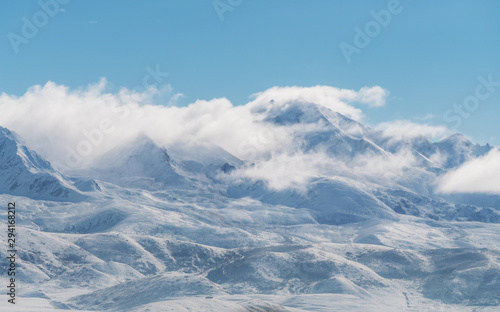 Panoramic snow mountains with white clouds and blue sky